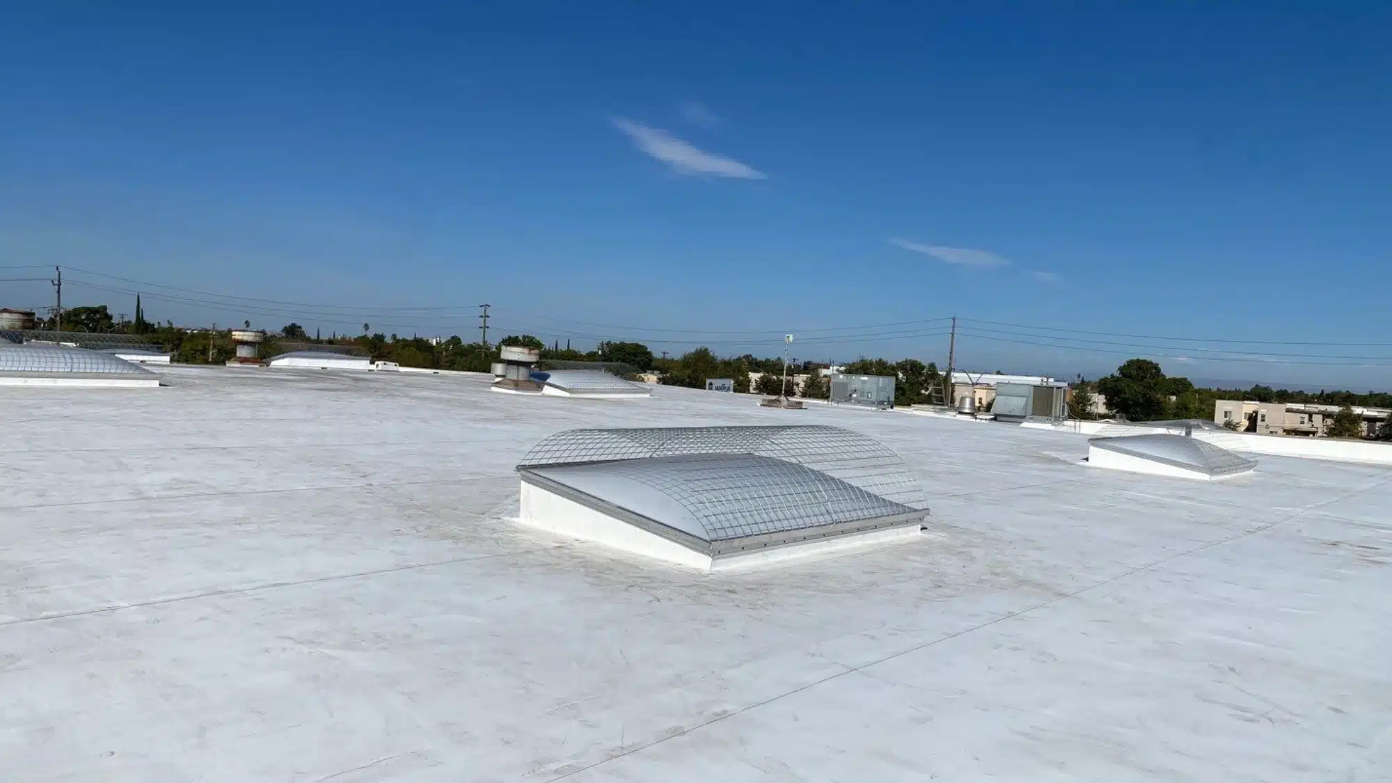 Commercial flat roof with a reflective protective coating designed to help reduce UV damage, resist weathering, and extend roof lifespan.