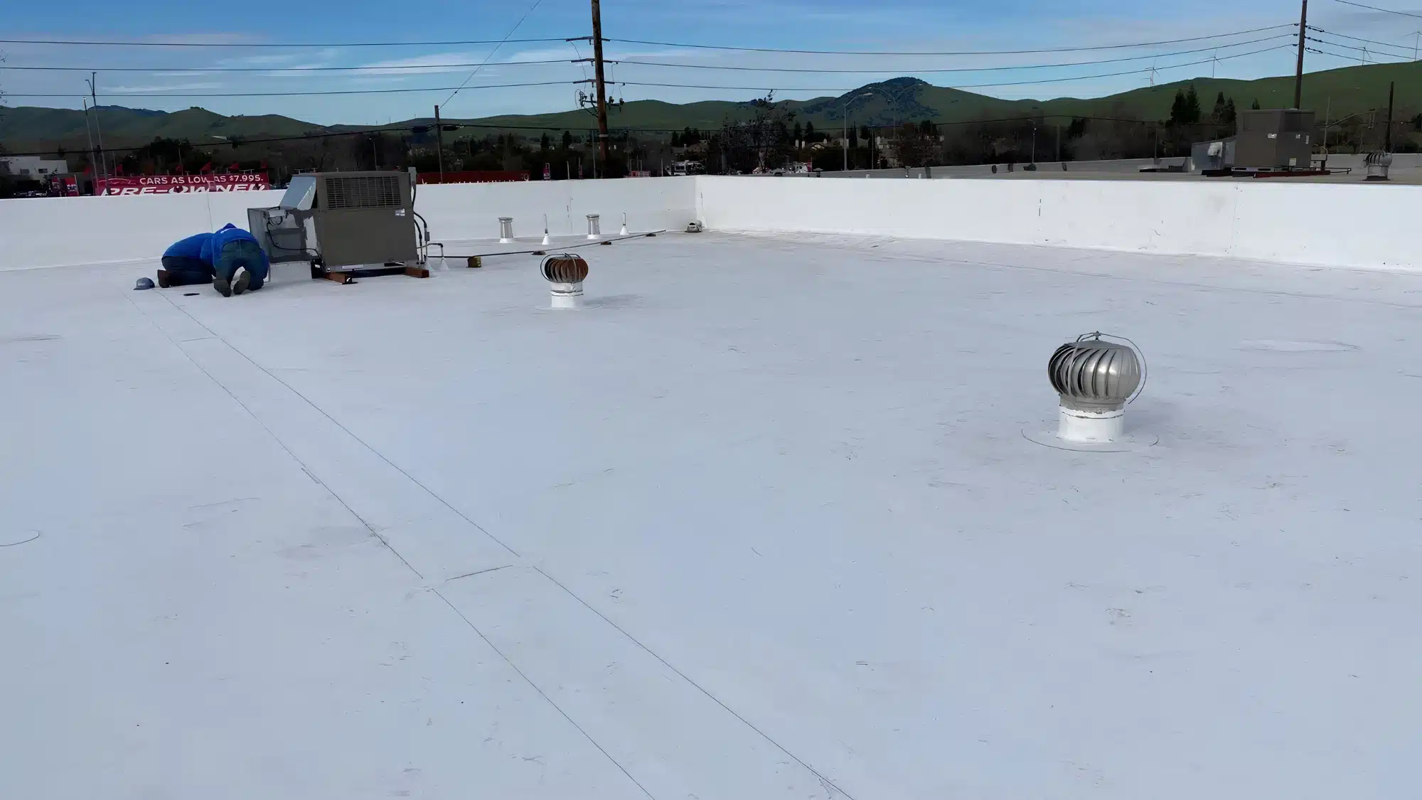 Roofing professional performing routine commercial roof maintenance in Antioch, California